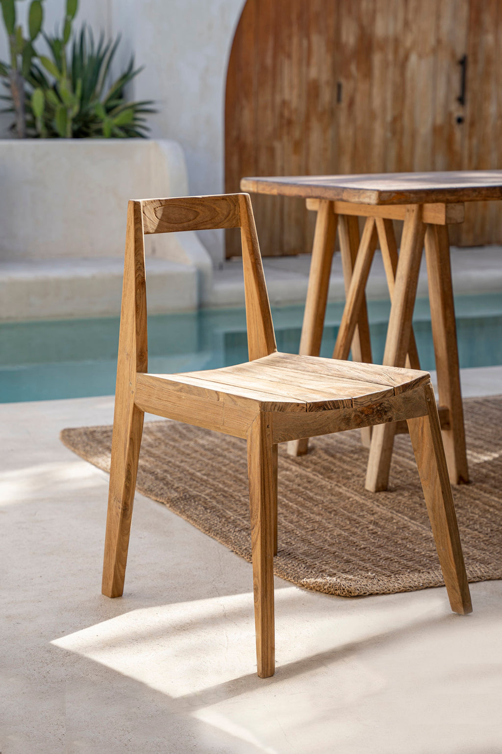 Chaise Paxi en teck sur une terrasse, au bord d'un bassin