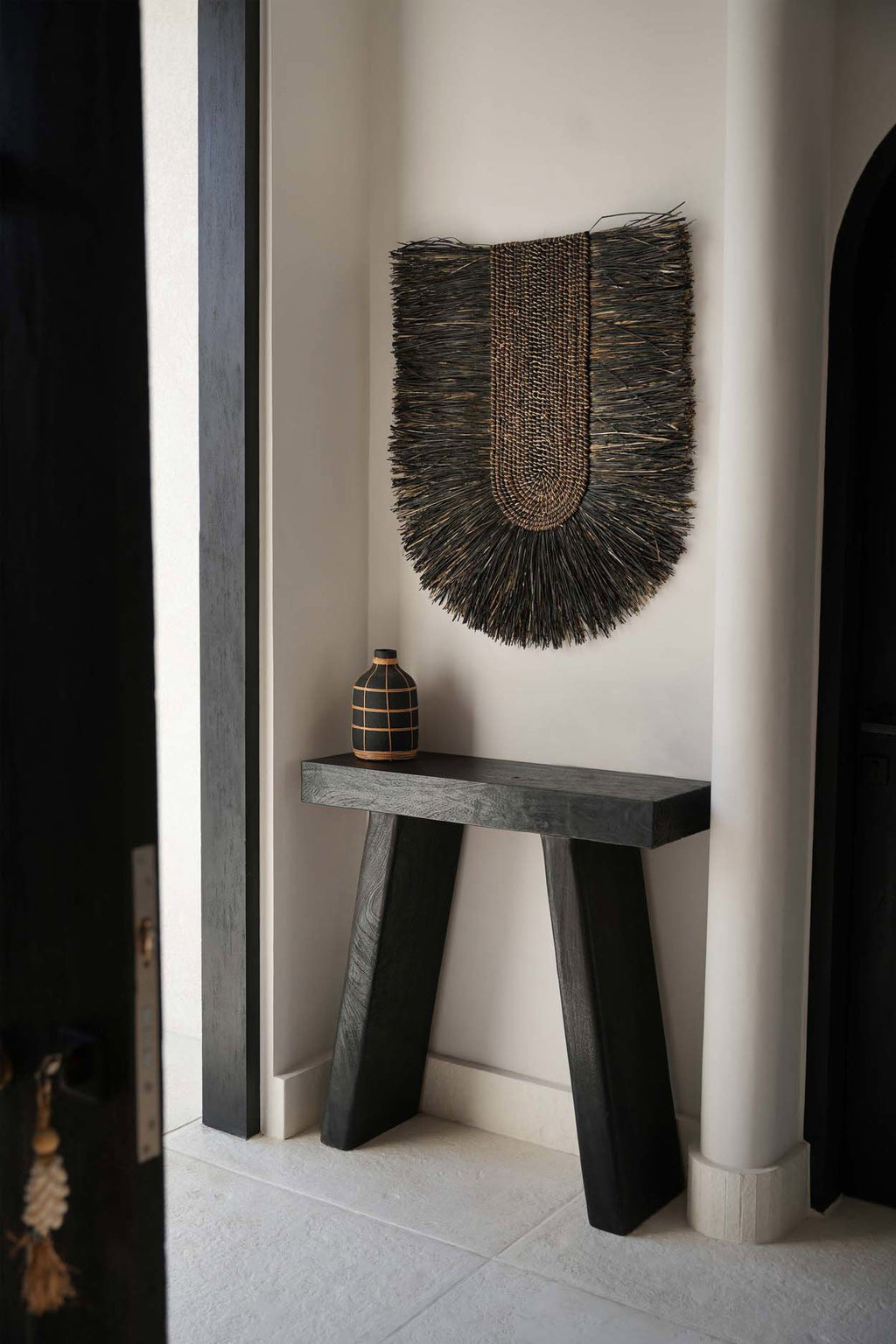 Décoration murale Dada noire dans un couloir clair, au-dessus d'un banc