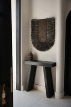 Décoration murale Dada noire dans un couloir clair, au-dessus d'un banc