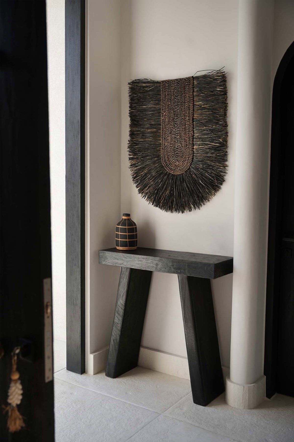Décoration murale Dada noire dans un couloir clair, au-dessus d'un banc