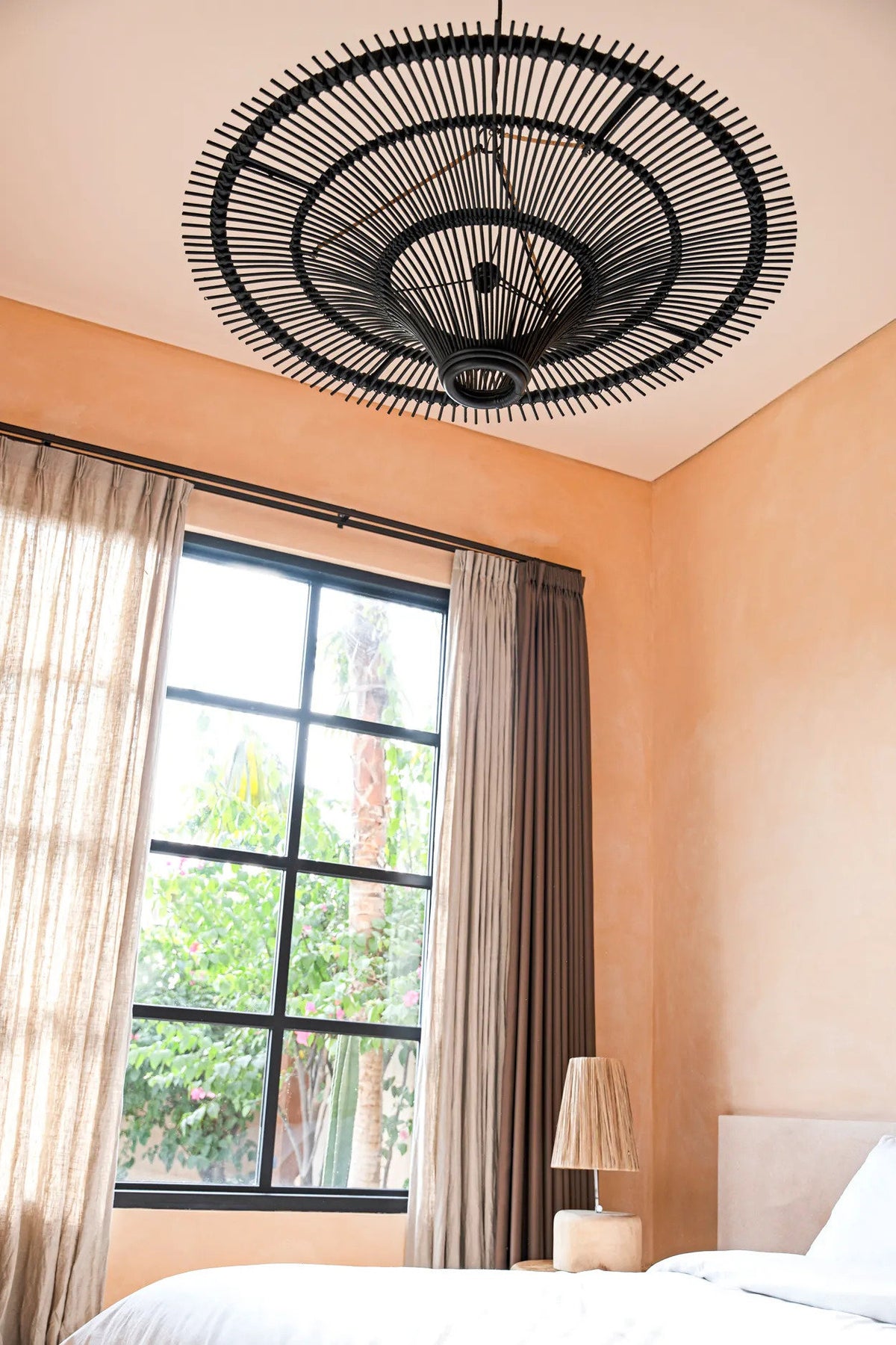 Suspension Le Ciel noire au plafond d'une chambre, mur ocre et grande fenêtre
