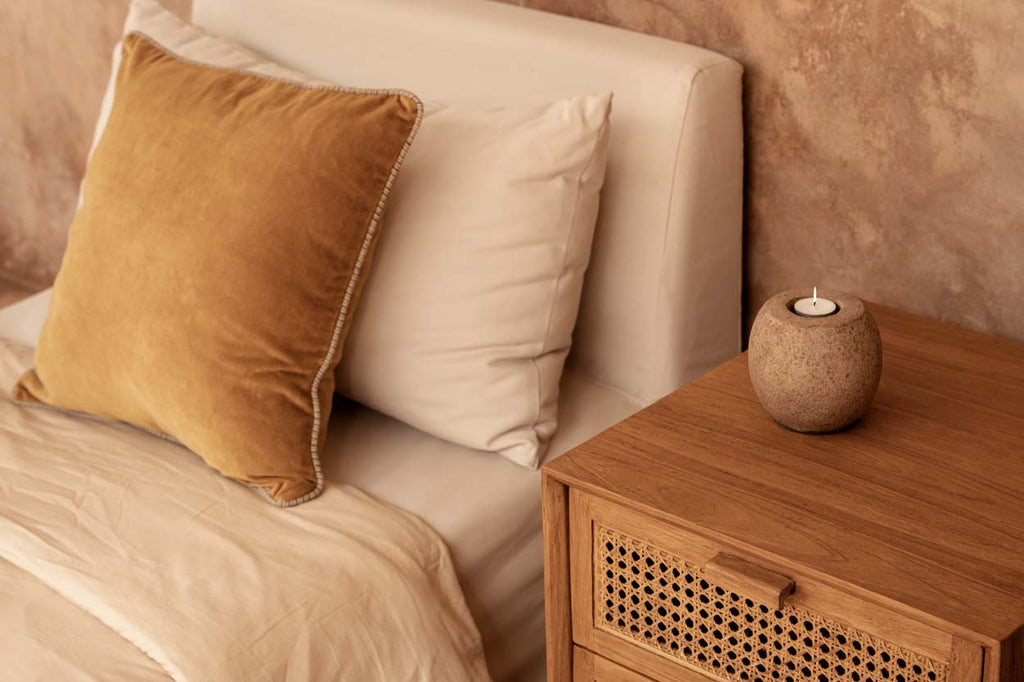 Table de chevet Harmony à côté d'un lit habillé de linge beige, vue rapprochée