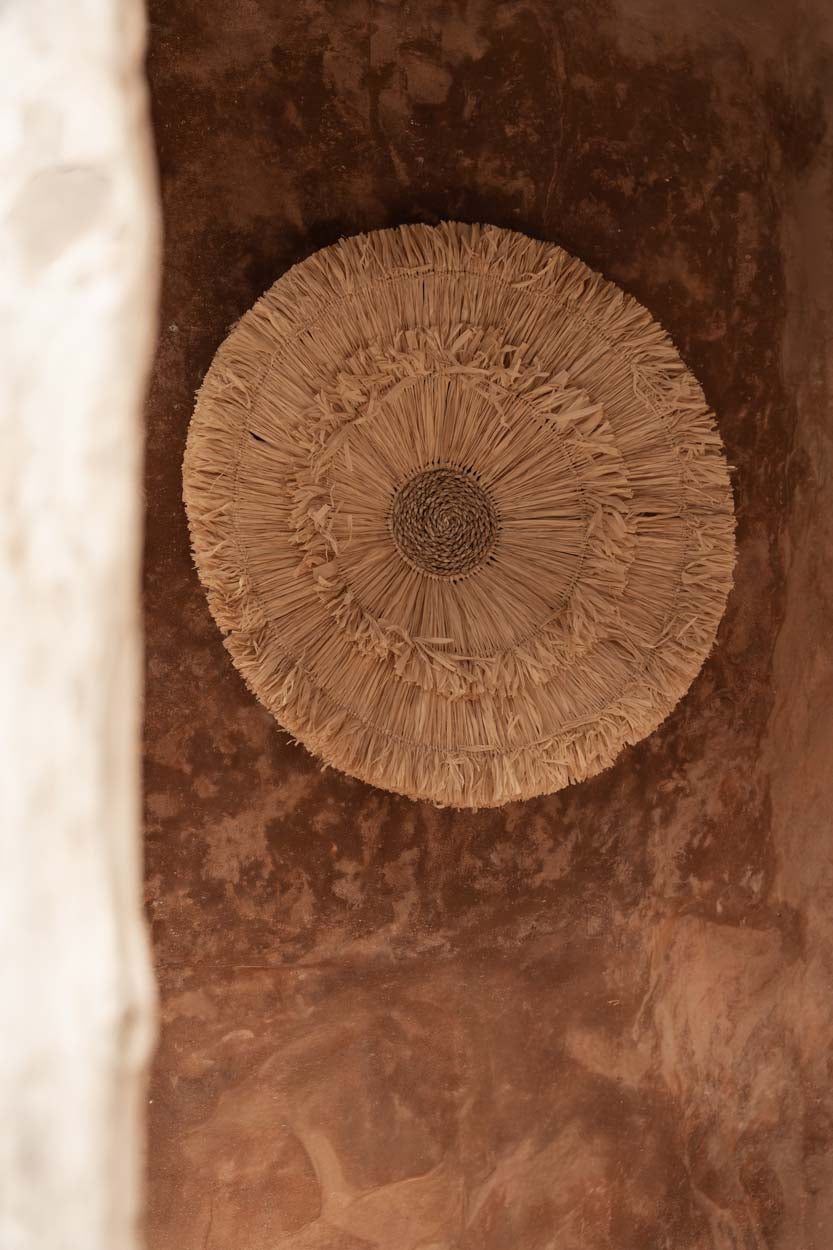 Décoration murale Wanita accrochée dans une niche aux murs terracotta