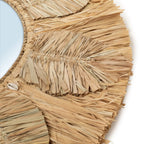 Gros plan sur les feuilles de raphia et les petits coquillages cauris du miroir Palmier