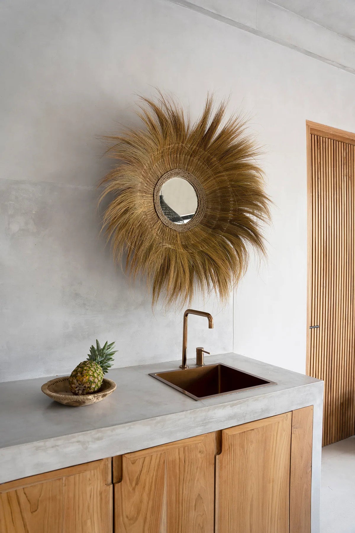 Miroir Sunken Forest accroché à un mur clair au-dessus d'un plan de travail en béton, en intérieur
