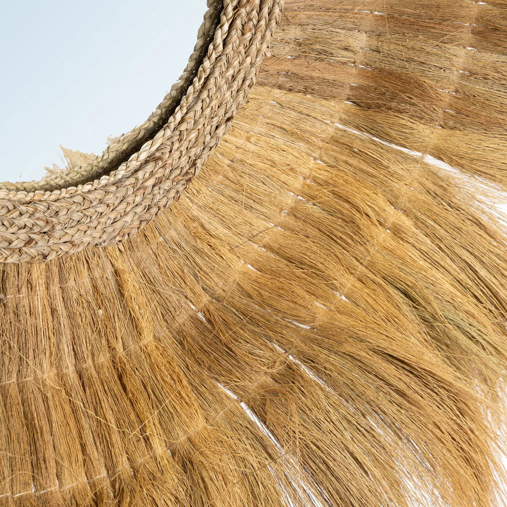 Gros plan sur les fibres d'herbe séchée et sur le tressage entourant le verre du miroir Sunken Forest