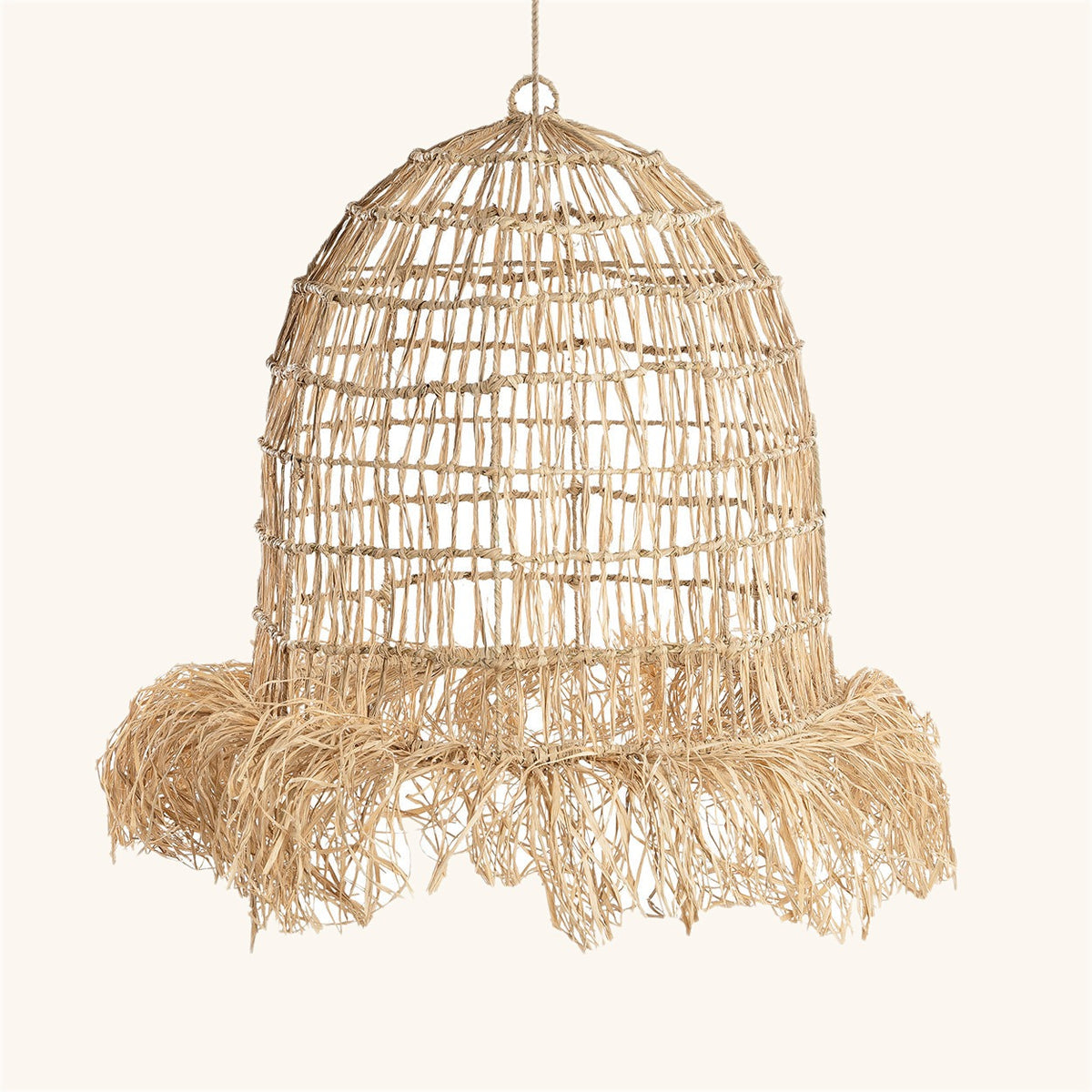 Abat-jour Casita en fibres naturelles tressées, cloche haute terminée par une frange, sur fond clair