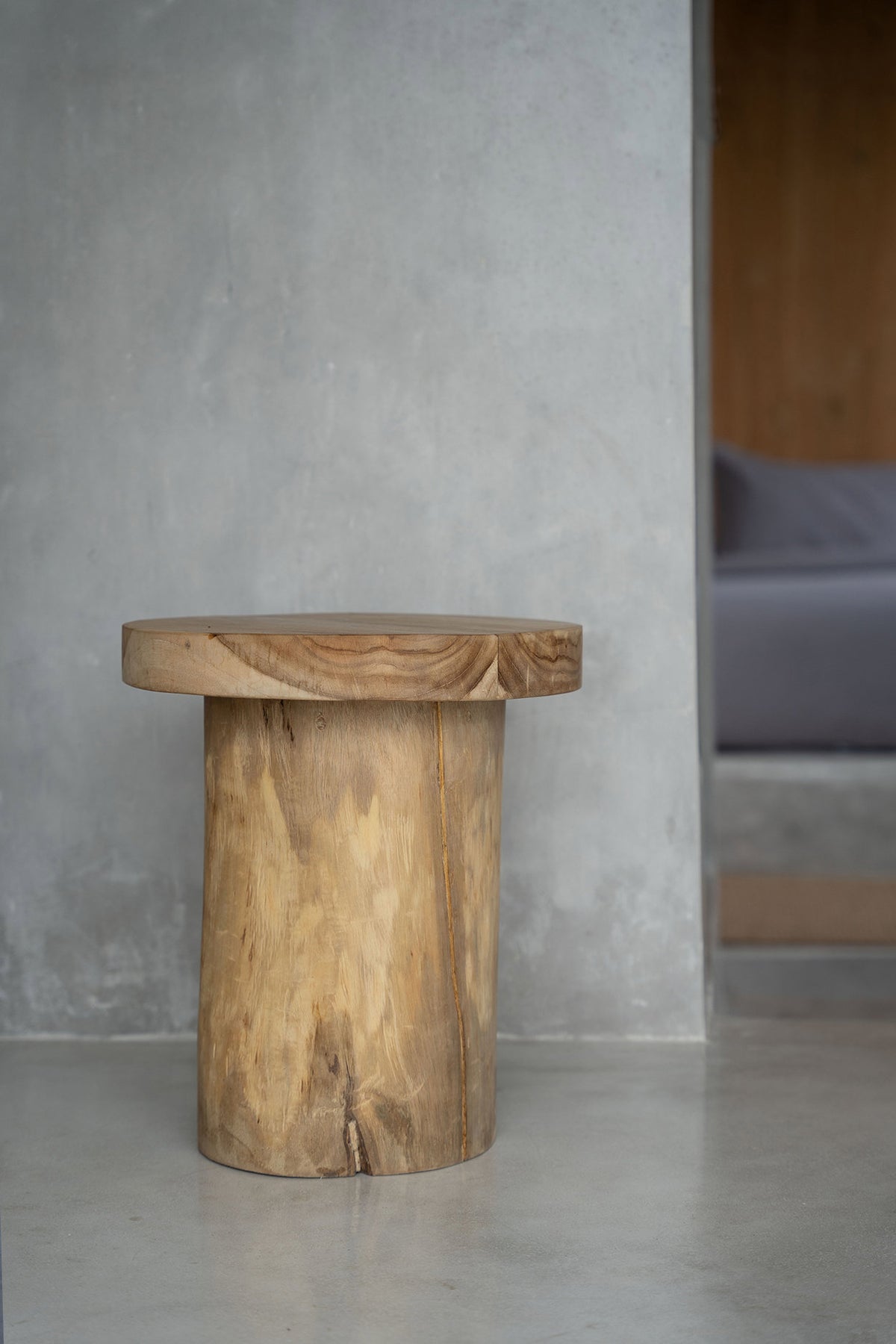 Table d'appoint Inti posée contre un mur clair dans un intérieur épuré